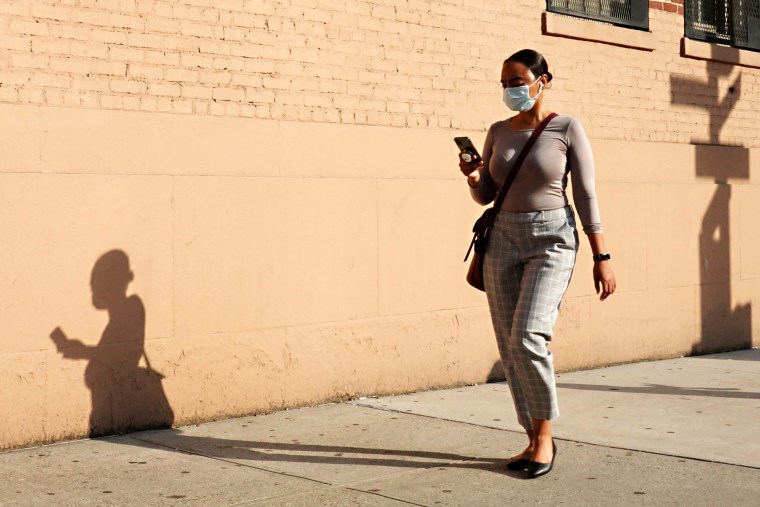 A woman wearing a protective mask walking