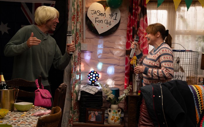 Sam - dressed as Jason Donovan - sings on the karaoke with Lydia in Emmerdale