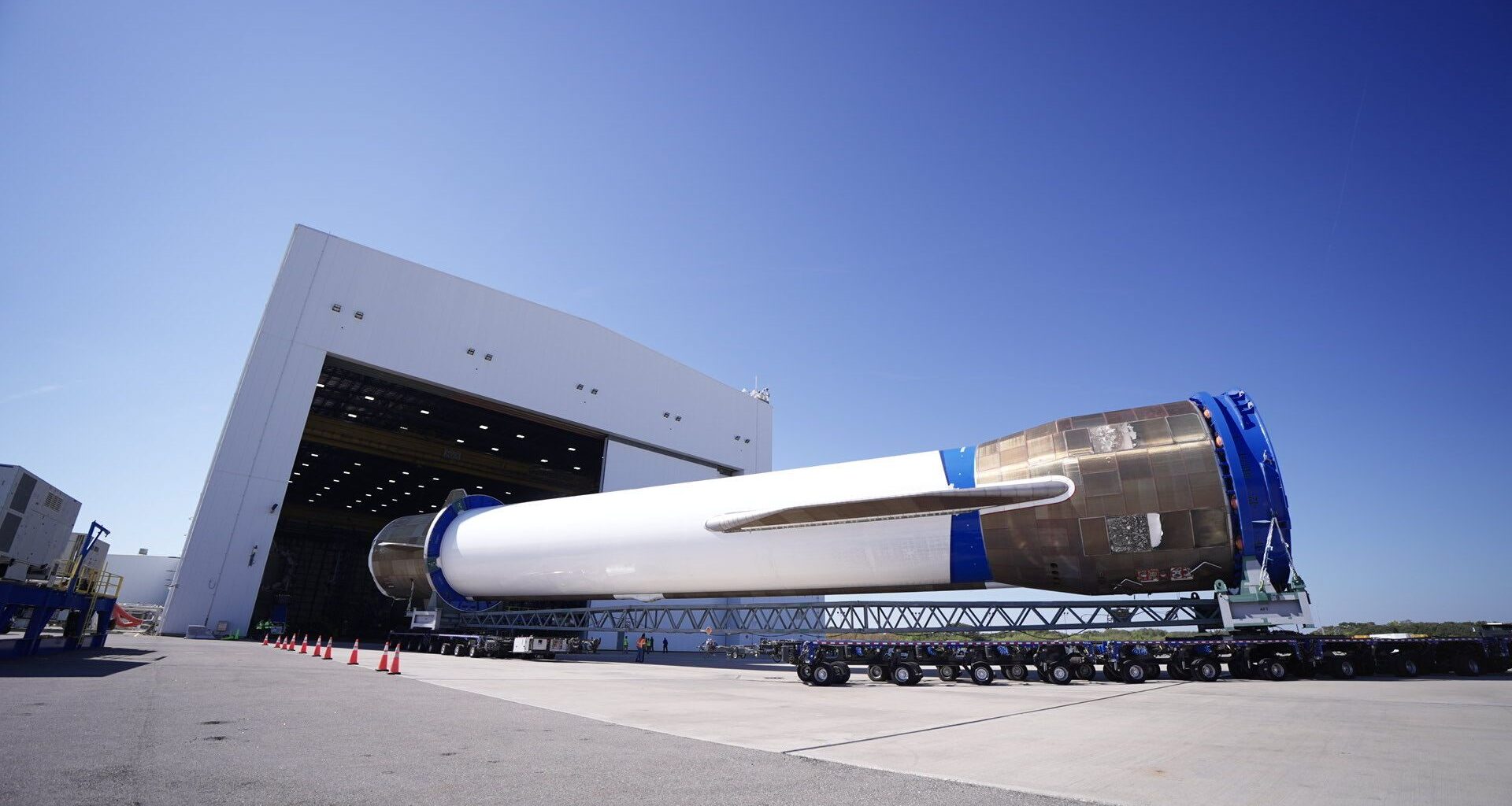 a large white rocket is rolled into a hangar horizontally