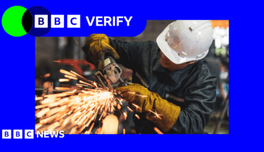 A picture of a person wearing a white hard hat and using a machine tool with sparks flying out