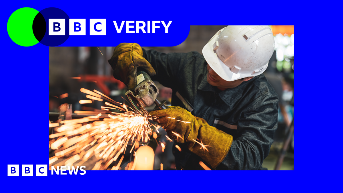 A picture of a person wearing a white hard hat and using a machine tool with sparks flying out