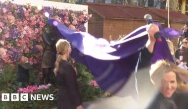 Actress Sally Phillips pulling purple rug and unveiling Bridget Jones statue