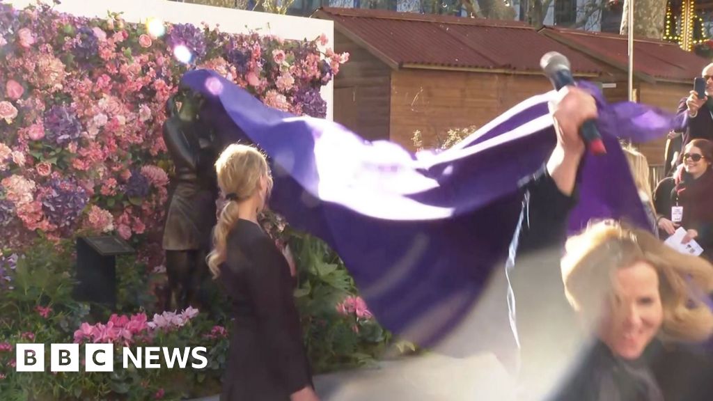 Actress Sally Phillips pulling purple rug and unveiling Bridget Jones statue
