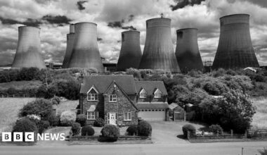 A house in front of Ratcliffe-on-Soar power station's cooling towers in black and white.
