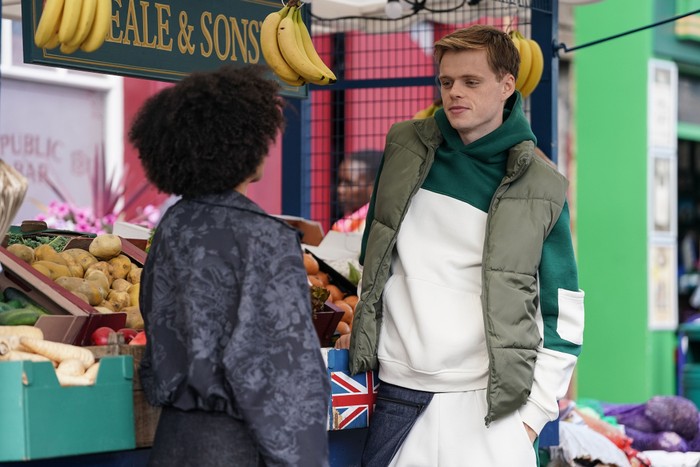 Oscar flirts with Jasmine beside the fruit and veg stall in EastEnders