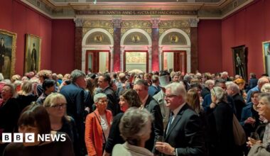 A woman takes a picture of two of Joseph Wright of Derby's pieces at a previous exhibition