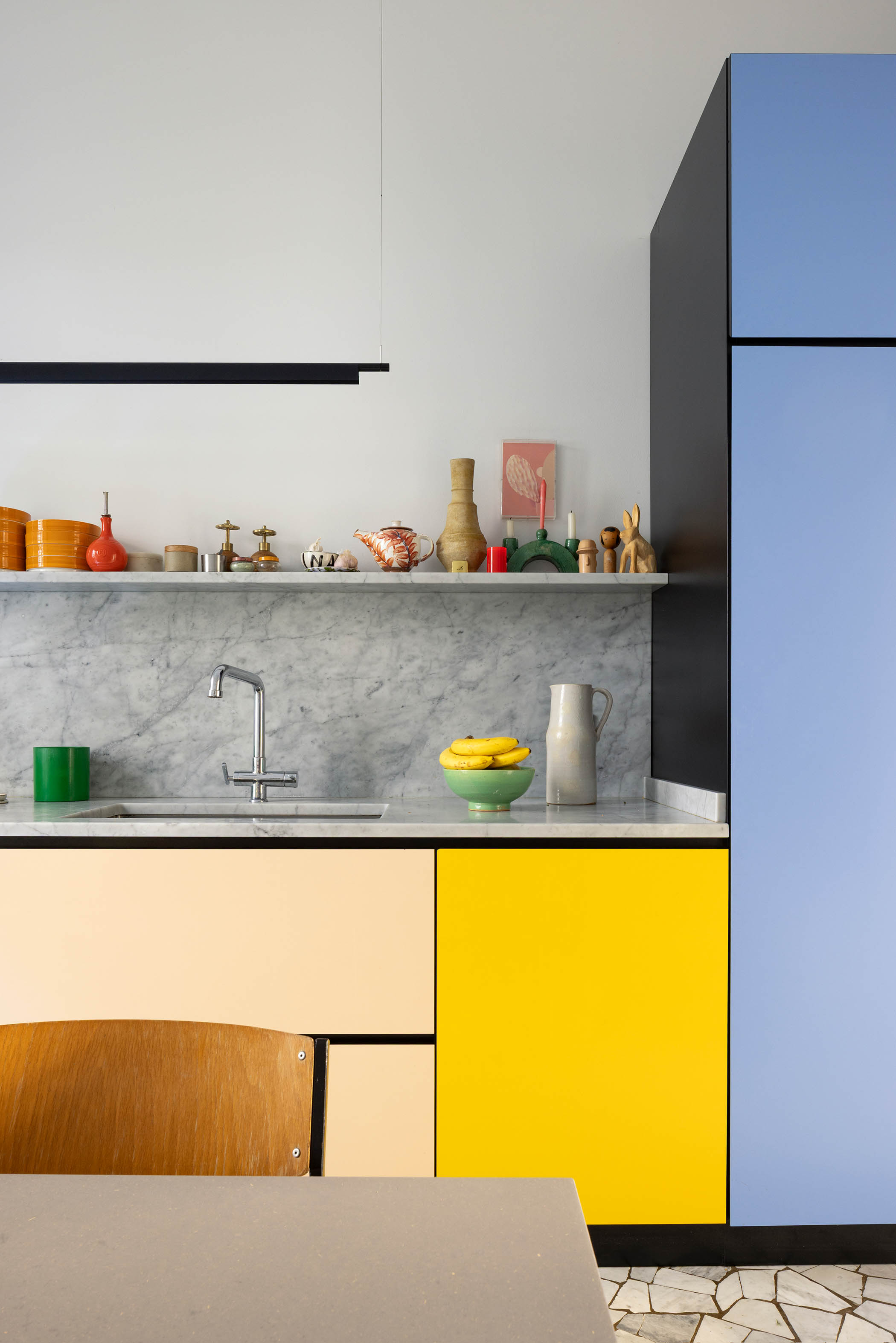 Marble tops and vibrant cabinets in the kitchen, designed by Andrew Haug