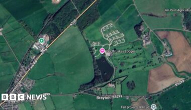 A Google Maps screenshot showing an aerial view of the location where North Lakes Lodges is. It is on a parcel of land between the A596 and the B5299. The area is mostly surrounded by green space.