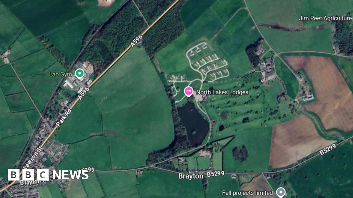 A Google Maps screenshot showing an aerial view of the location where North Lakes Lodges is. It is on a parcel of land between the A596 and the B5299. The area is mostly surrounded by green space.