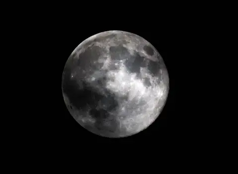 Neil Hall / EPA A large round grey Moon is pictured against a dark starless night sky, with crater and contour detail visible on the Moon, in London on Wednesday.