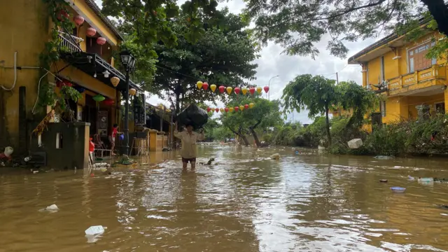 A man wades through a flooded area in Hoi An, following deadly floods in central Vietnam.