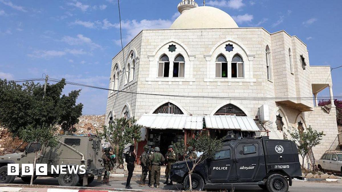 Israeli security forces stand next to their vehicles as they inspect the Hajja Hamida Mosque after it was set on fire and vandalised by Israeli settlers in the Palestinian village of Deir Istiya