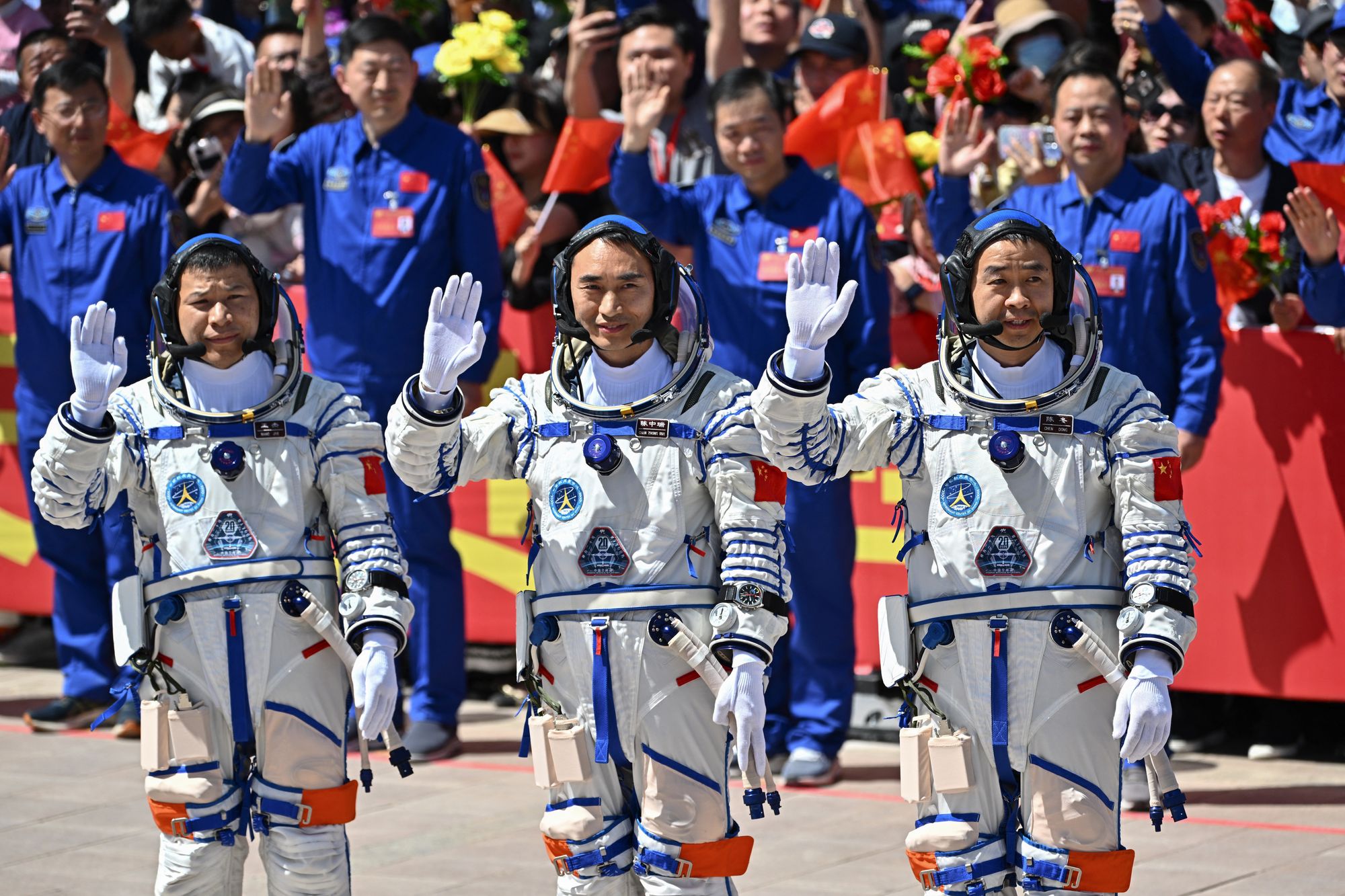 China's Shenzhou-20 space mission (L-R) Wang Jie, Chen Zhongrui, and Chen Dong, wave during a departure ceremony