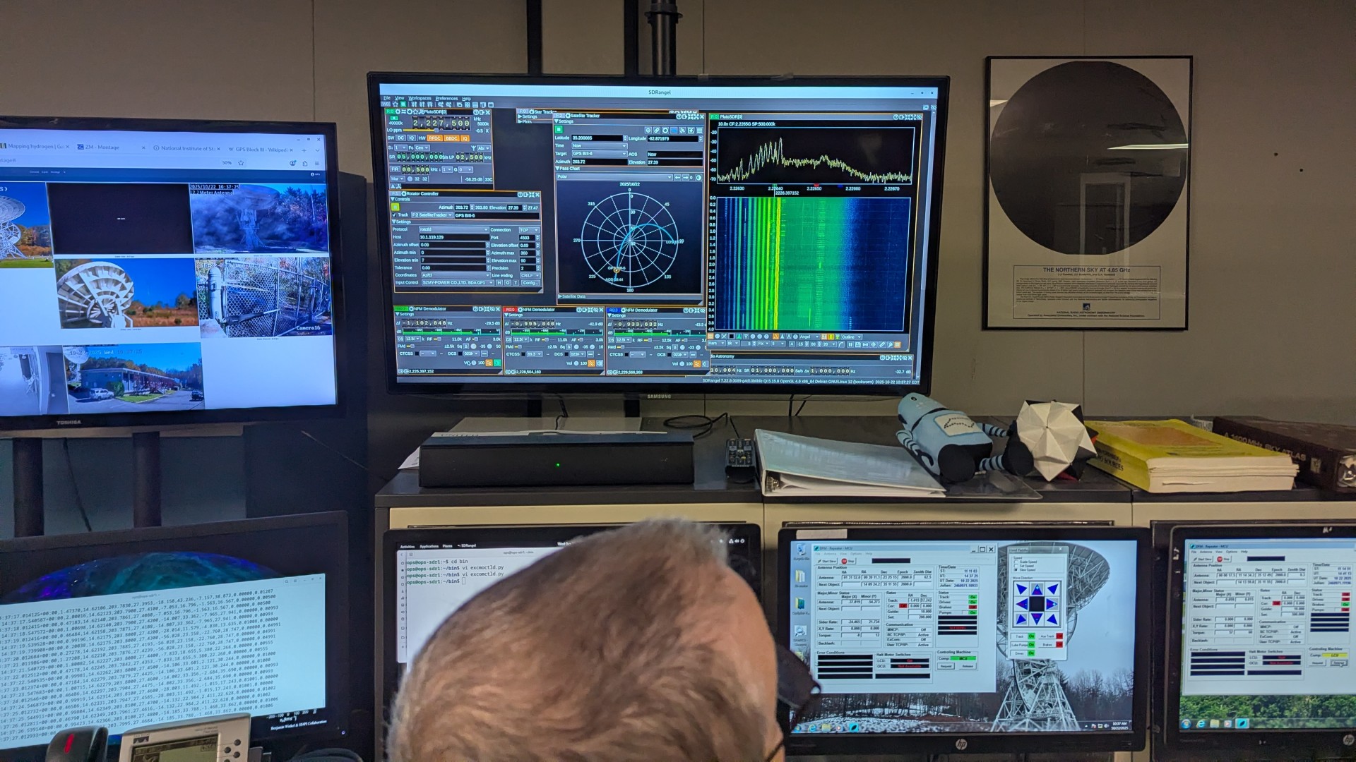 a man sits at a row of computers in an industrial building