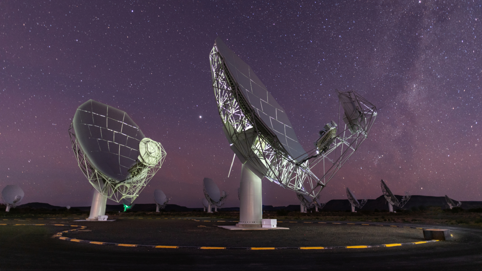 A photo of two radio dishes pointed up at the night sky