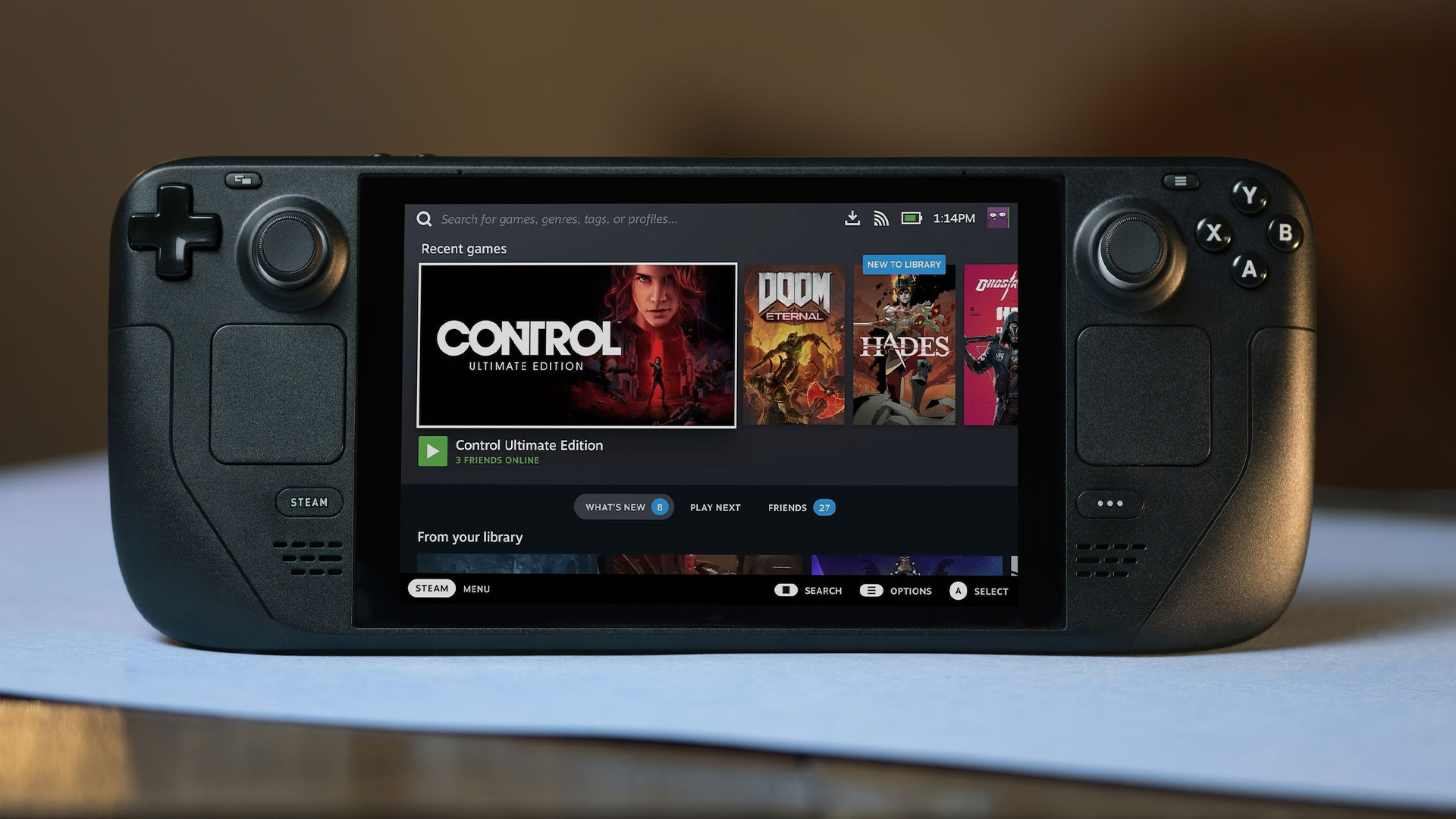 Steam Deck on a desk, showing the home screen