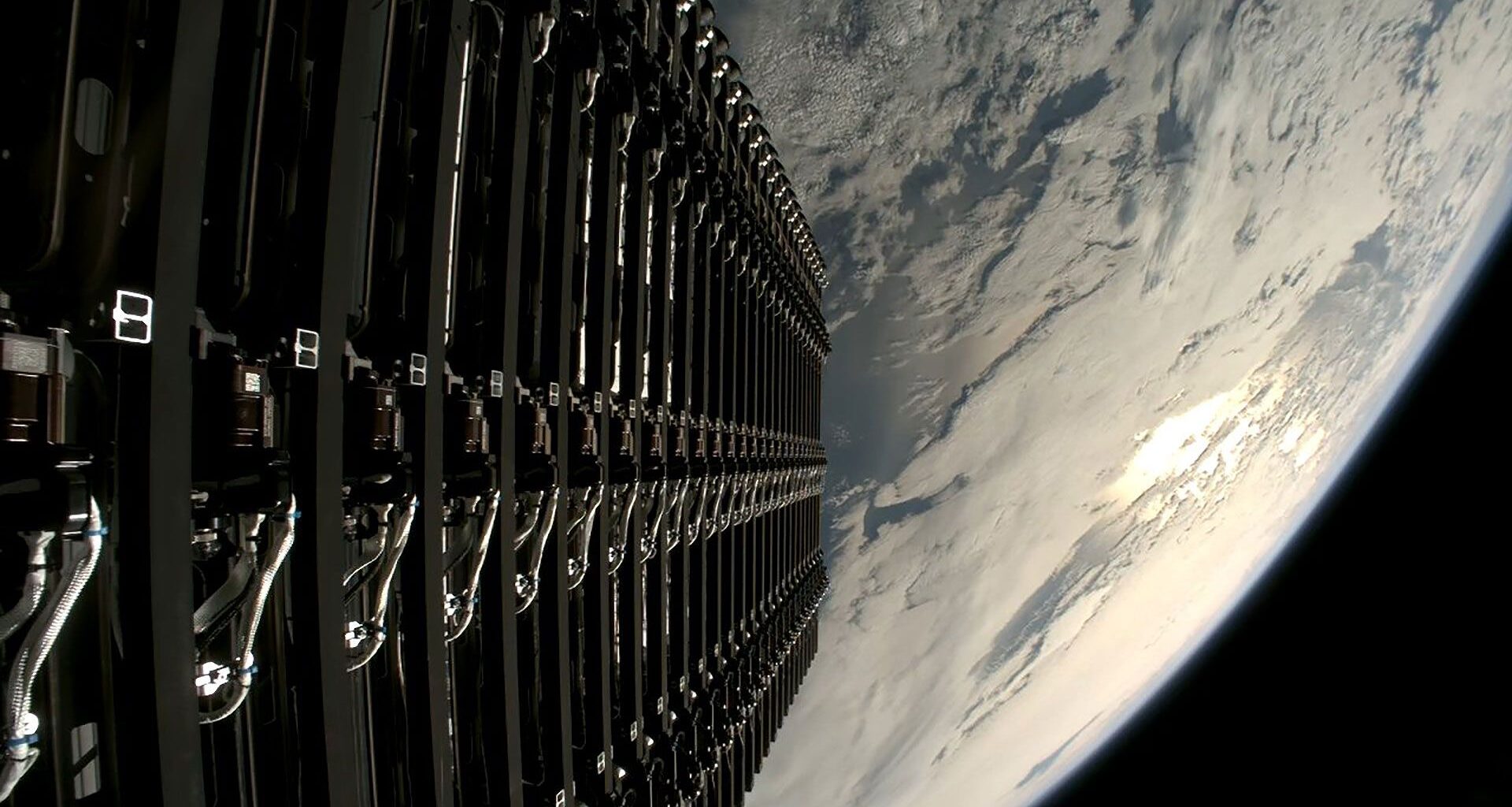 a stacked series of small satellites are seen ready to be deployed into low earth orbit.