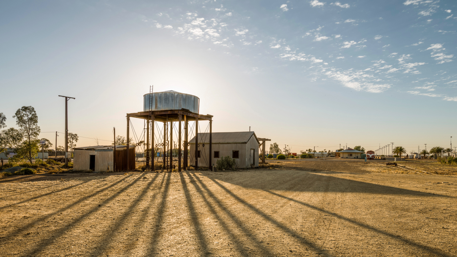 A photo of a water tower in front of a small town in the Australian outback