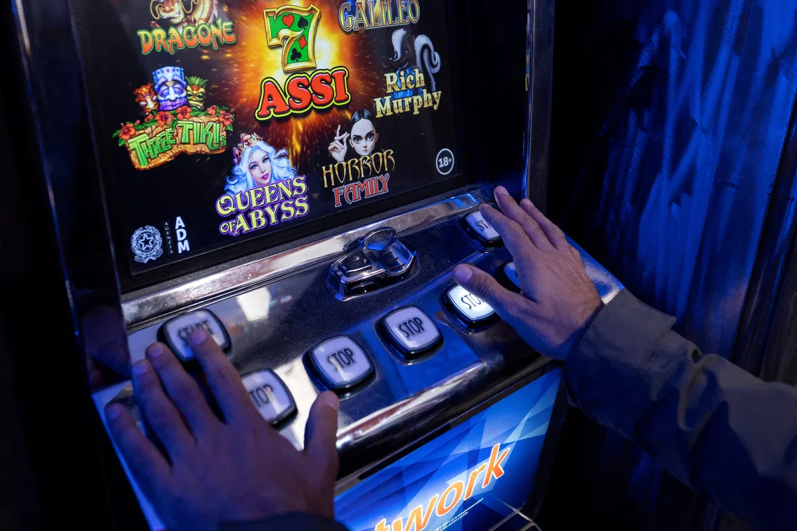 A man plays a slot machine in a shop in Rome, Italy, October 29, 2025. REUTERS/Remo Casilli