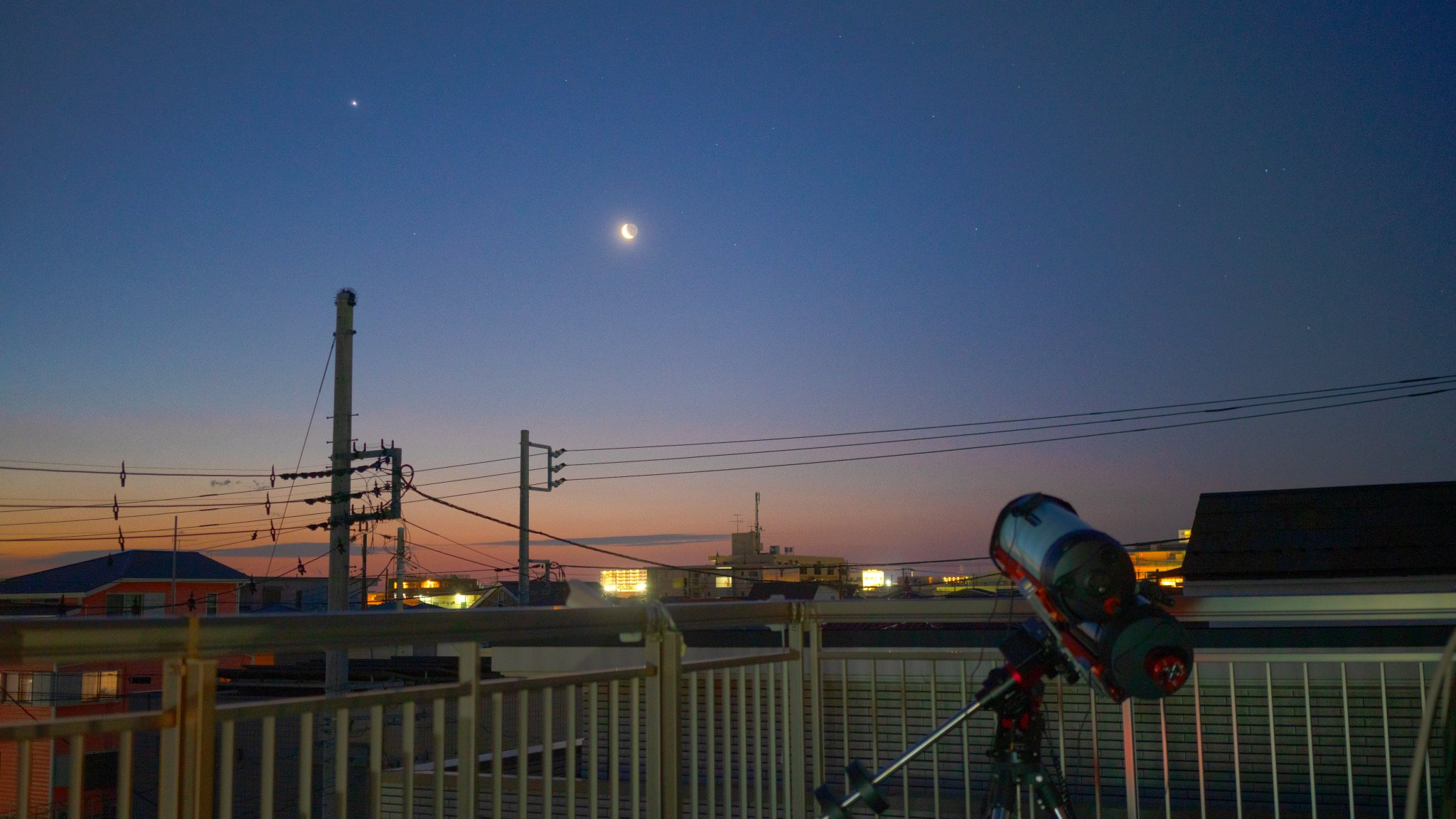 a lovely astronomy scene with twilight sky and the moon shining bright with a telescope in the foreground pointing at the moon.