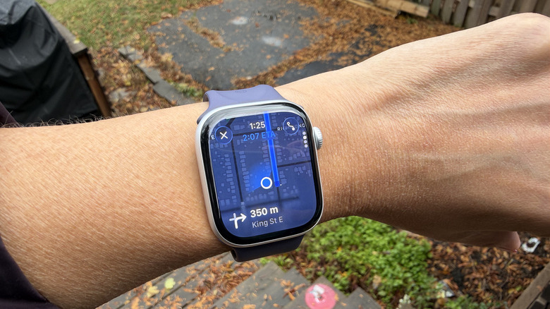 An Apple Watch on a wrist showing Apple Maps directions.