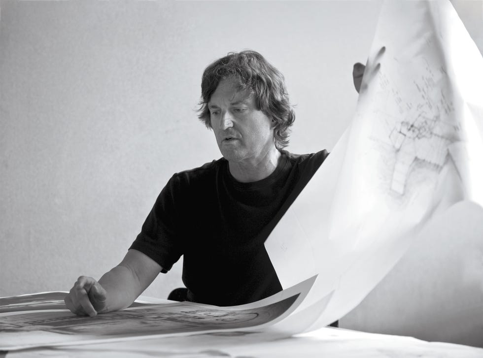 Individual holding a large blueprint.