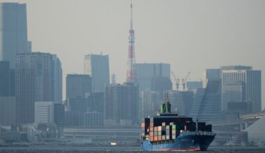 Tokyo Tower is seen amid tall buildings as a container ship leaves a cargo terminal in Tokyo, Wednesday, April 9, 2025. Photo: VCG