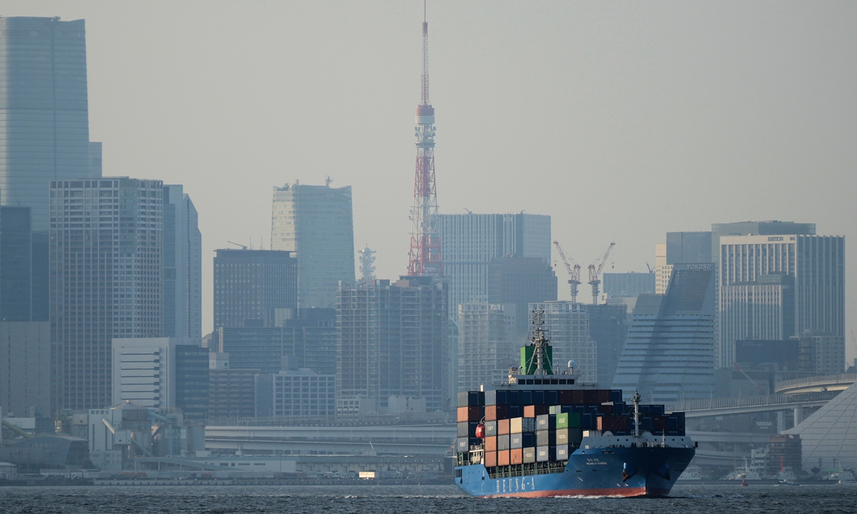 Tokyo Tower is seen amid tall buildings as a container ship leaves a cargo terminal in Tokyo, Wednesday, April 9, 2025. Photo: VCG