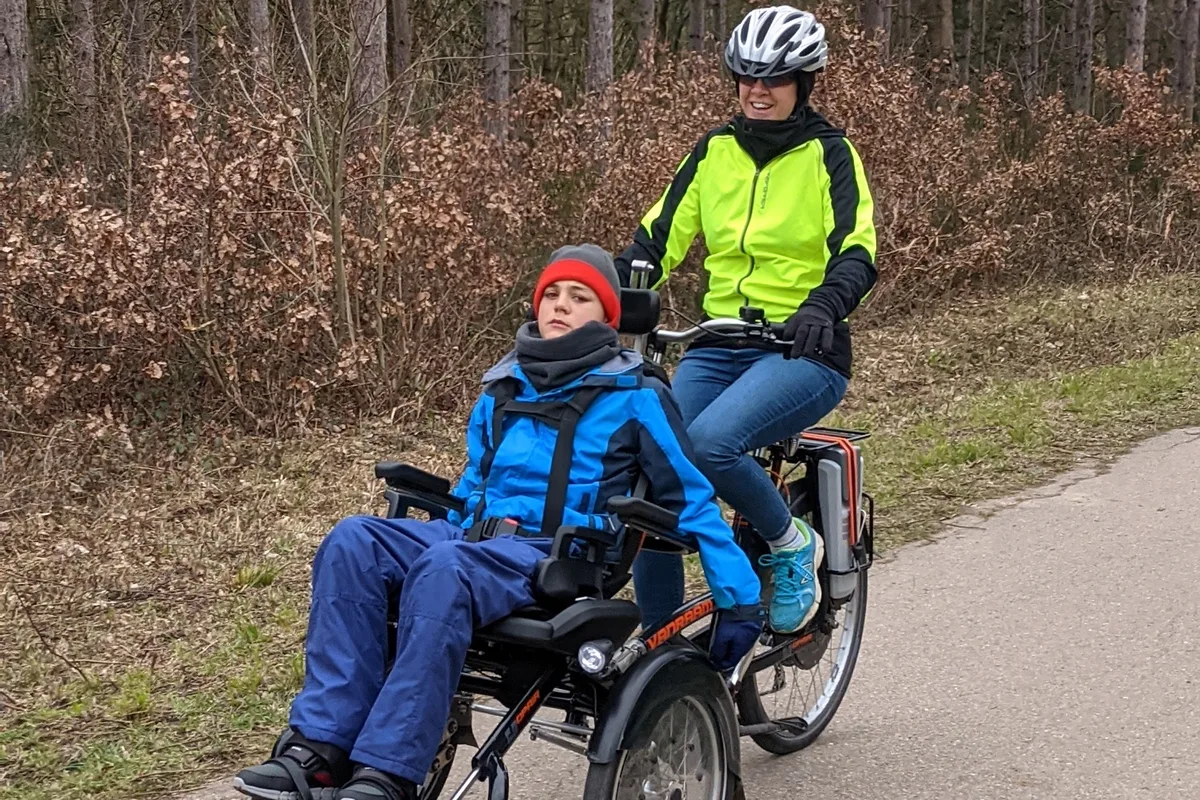 Woman riding with Van Raam OPair electric wheelcahir bike with son