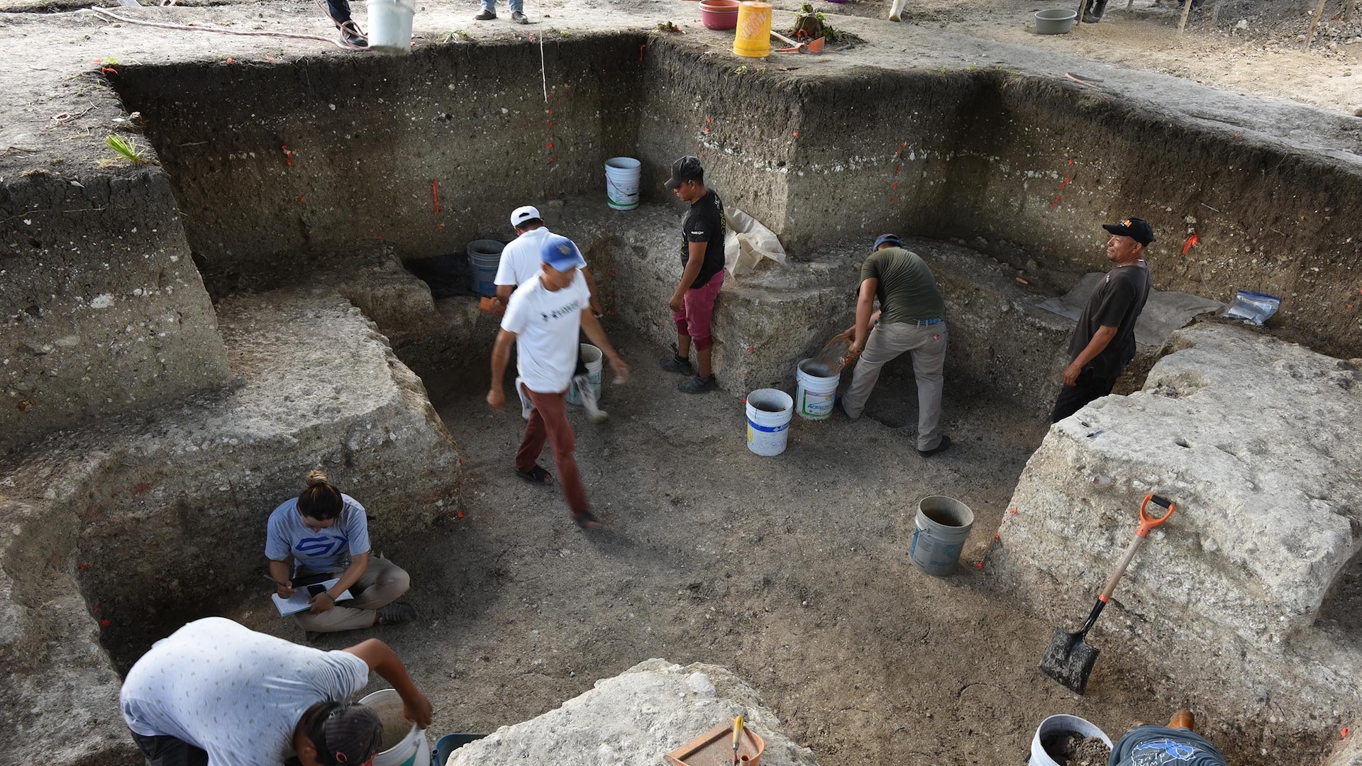 a group of archaeologists excavates a cross-shaped room