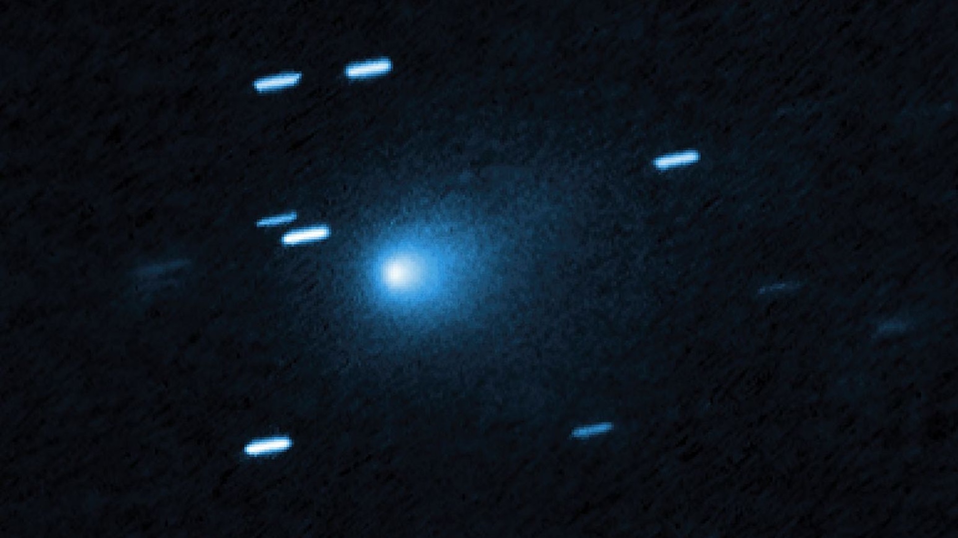 A blurry image of a blue comet streaking through outer space