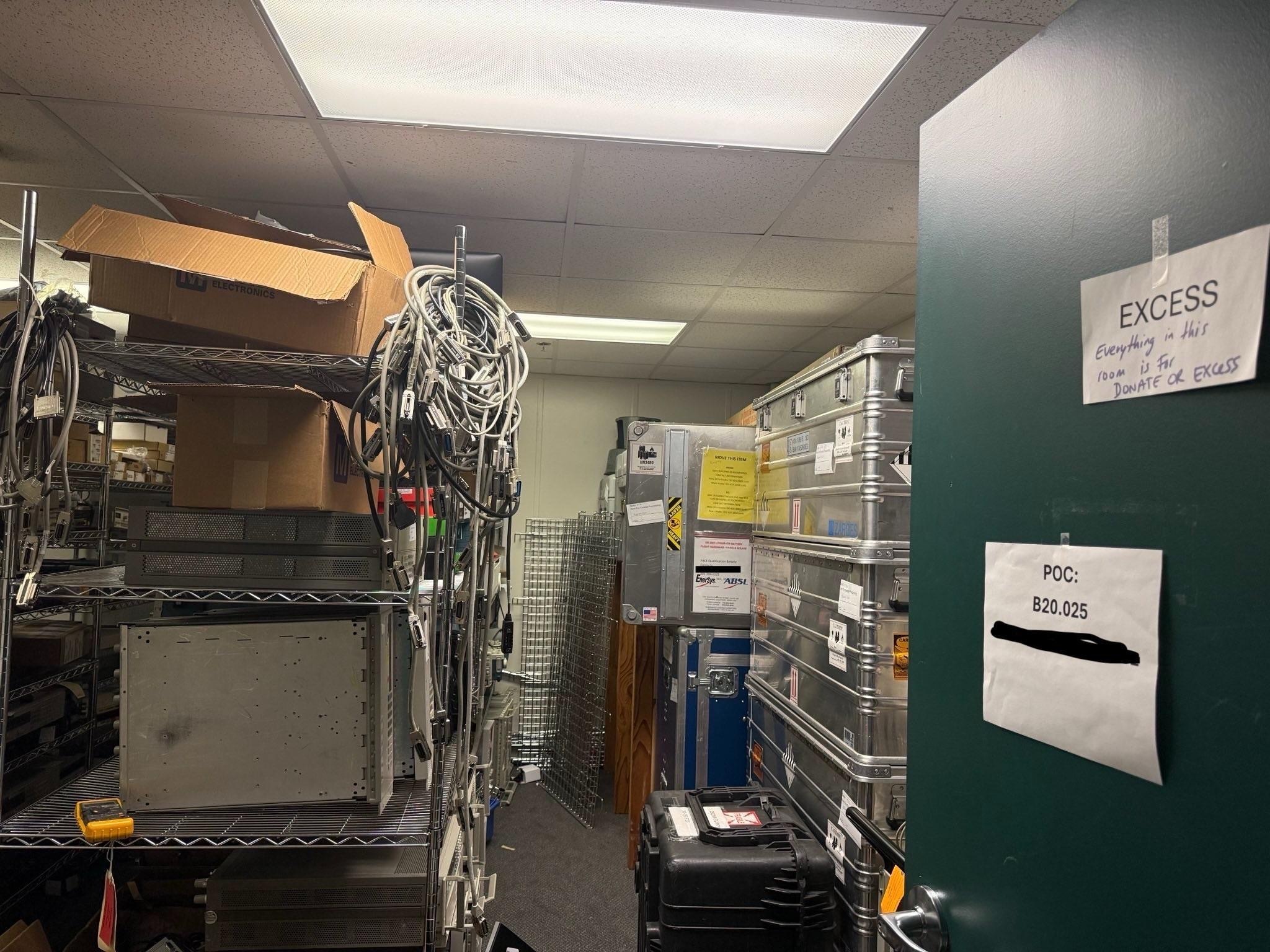 Various office spaces including desks, shelves and warehouses full of items stacked ready to be removed. 