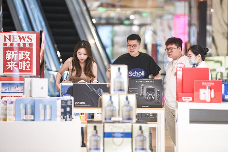 Men and women look at boxed goods in a store.