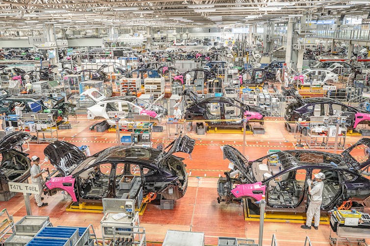 Car parts are fitted in a big warehouse.