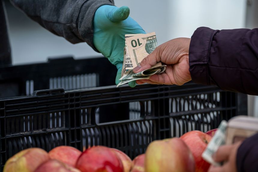 A shopper pays for produce at a farmer's market in San Francisco on March 27.