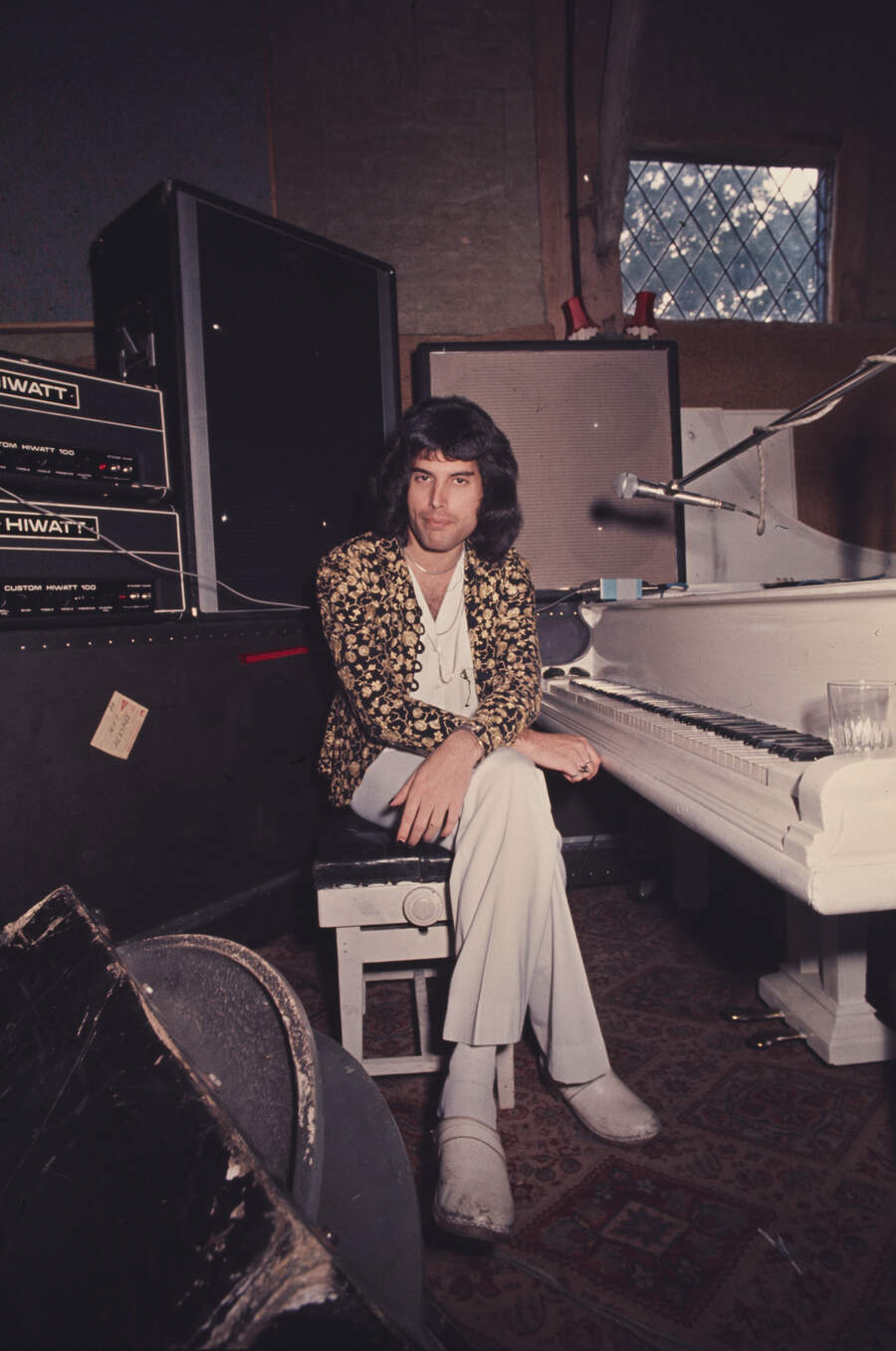 Freddie Mercury of Queen sitting at a white grand piano at Ridge Farm Studio during the recording of their album 'A Night At The Opera', Surrey, United Kingdom, 14th July 1975.