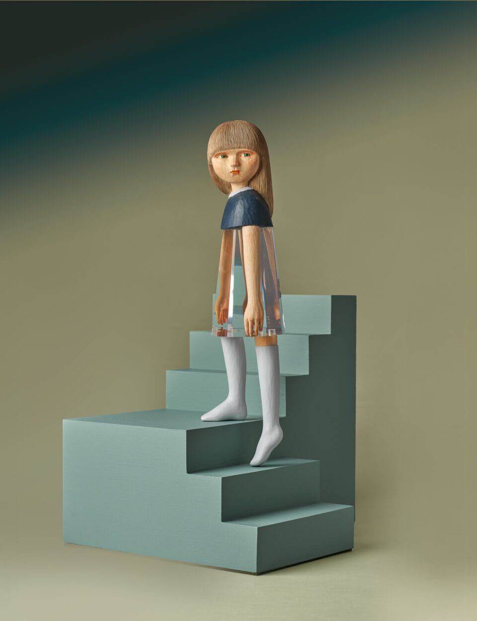 a small sculpture by Ayako Kita made of cypress and acrylic resin, depicting a young woman walking up a short flight of blue-gray steps and looking back