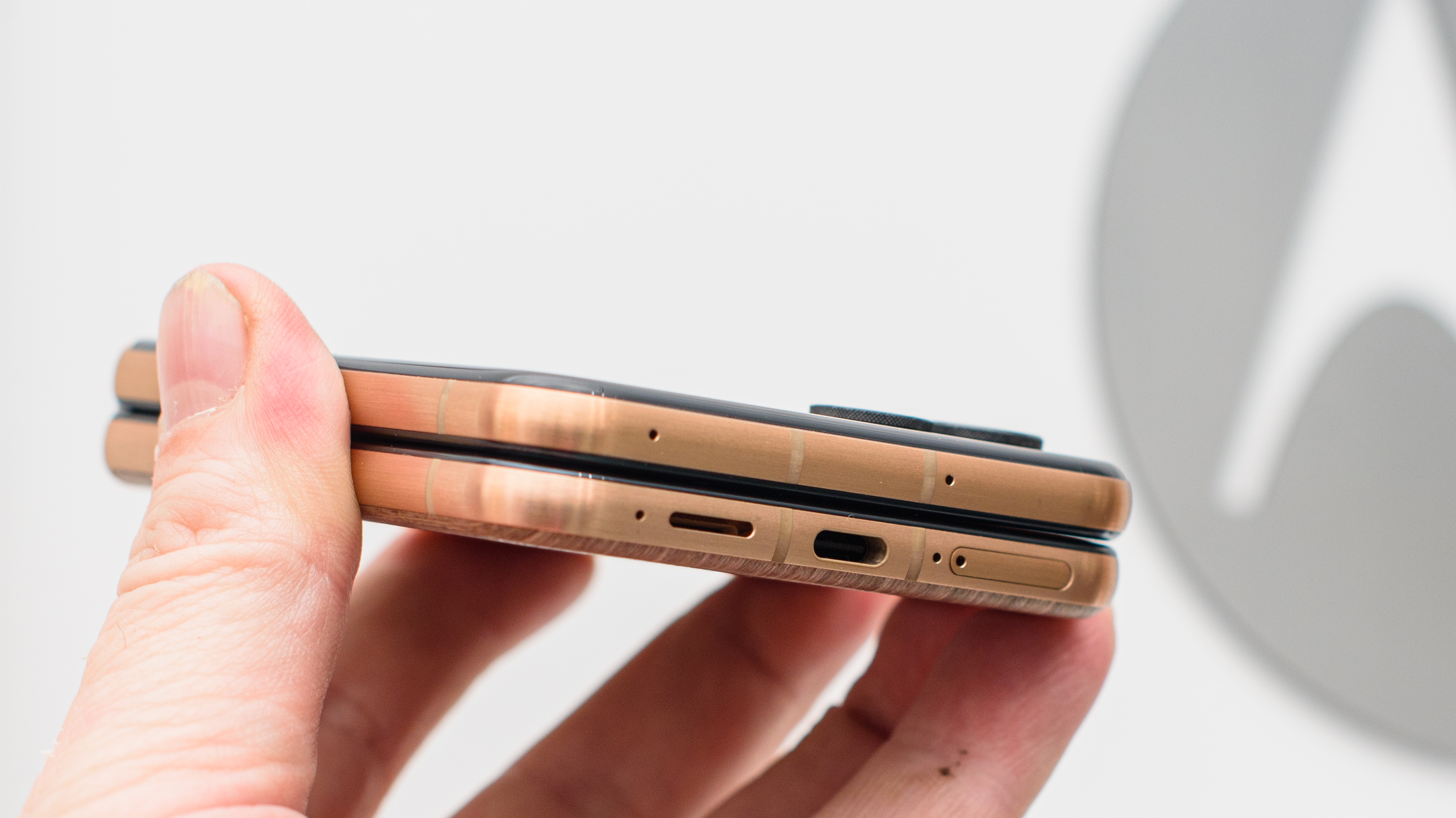 Motorola Razr Ultra (2025) in wood grain from side showing USB-C port on bottom