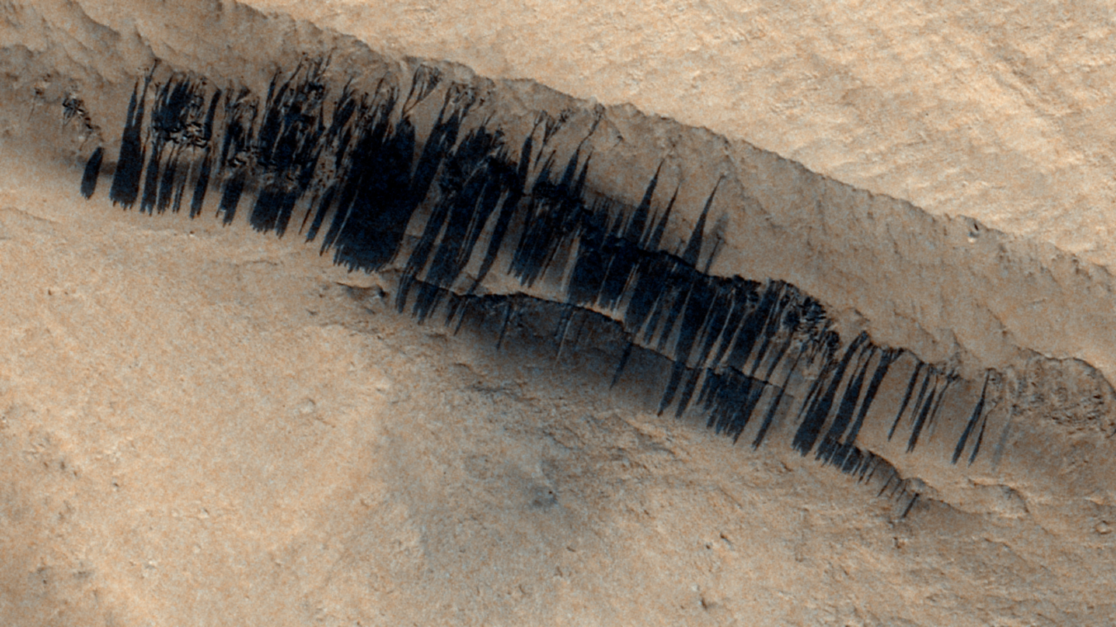 A satellite photo showing a hundreds of parallel slope streaks on the slopes of Apollinaris Mons