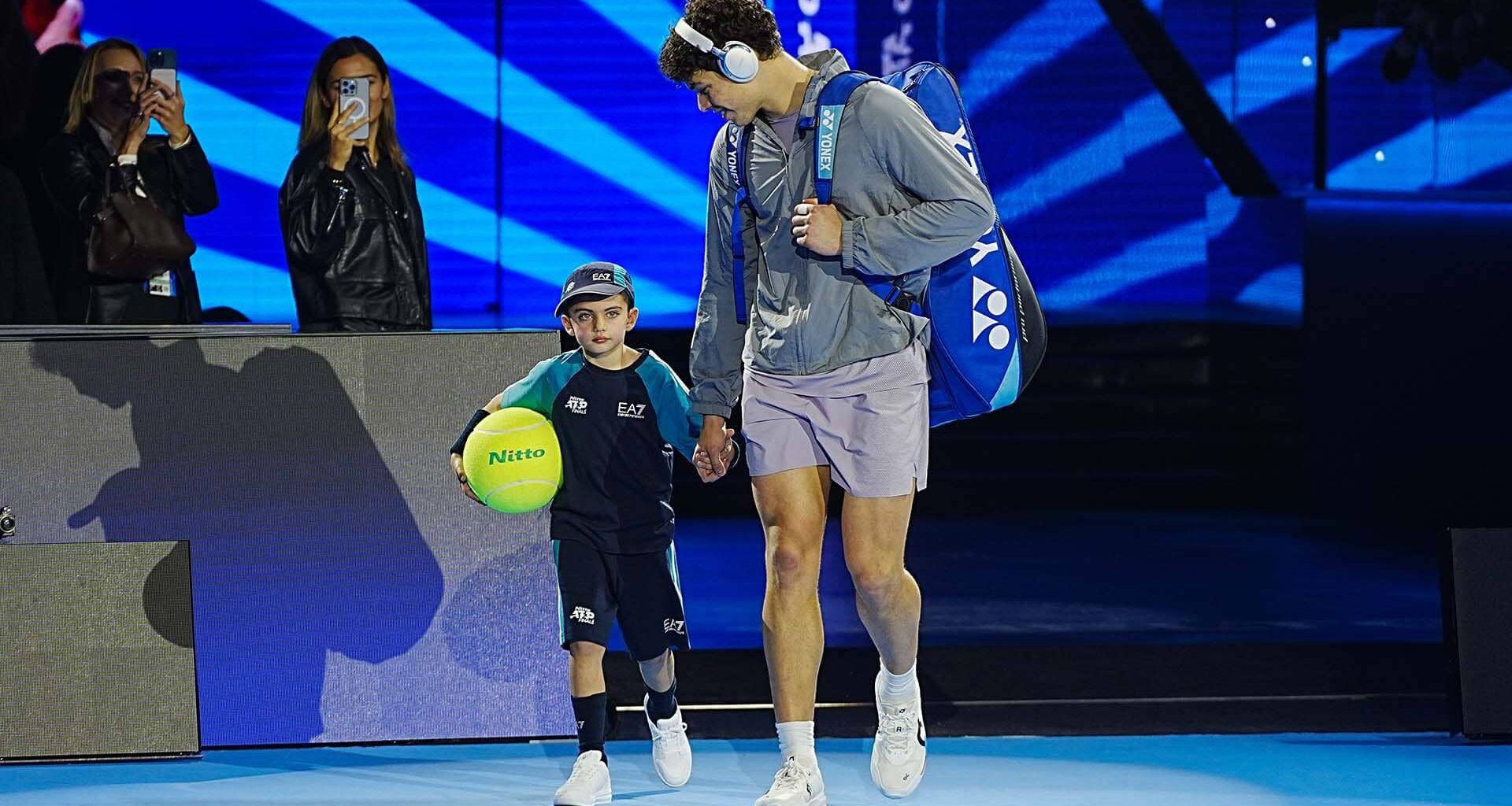 Nitto mascot Gioele walks on court with Ben Shelton on Sunday in Turin.