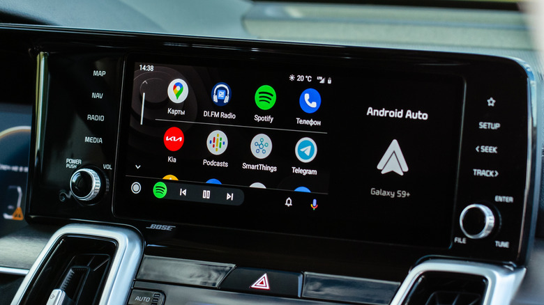 A vehicle infotainment screen displaying Android Auto, the logo is prominent on the right-hand side of the screen and multiple apps are displayed