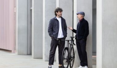 Two men talk with a bike in between them