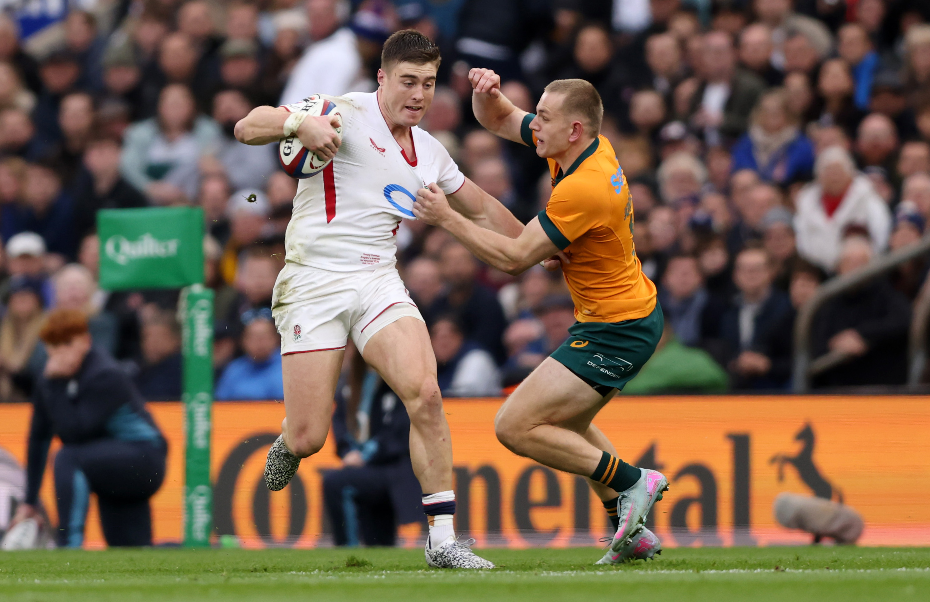 Tommy Freeman of England is tackled by Max Jorgensen of Australia during a rugby international match.