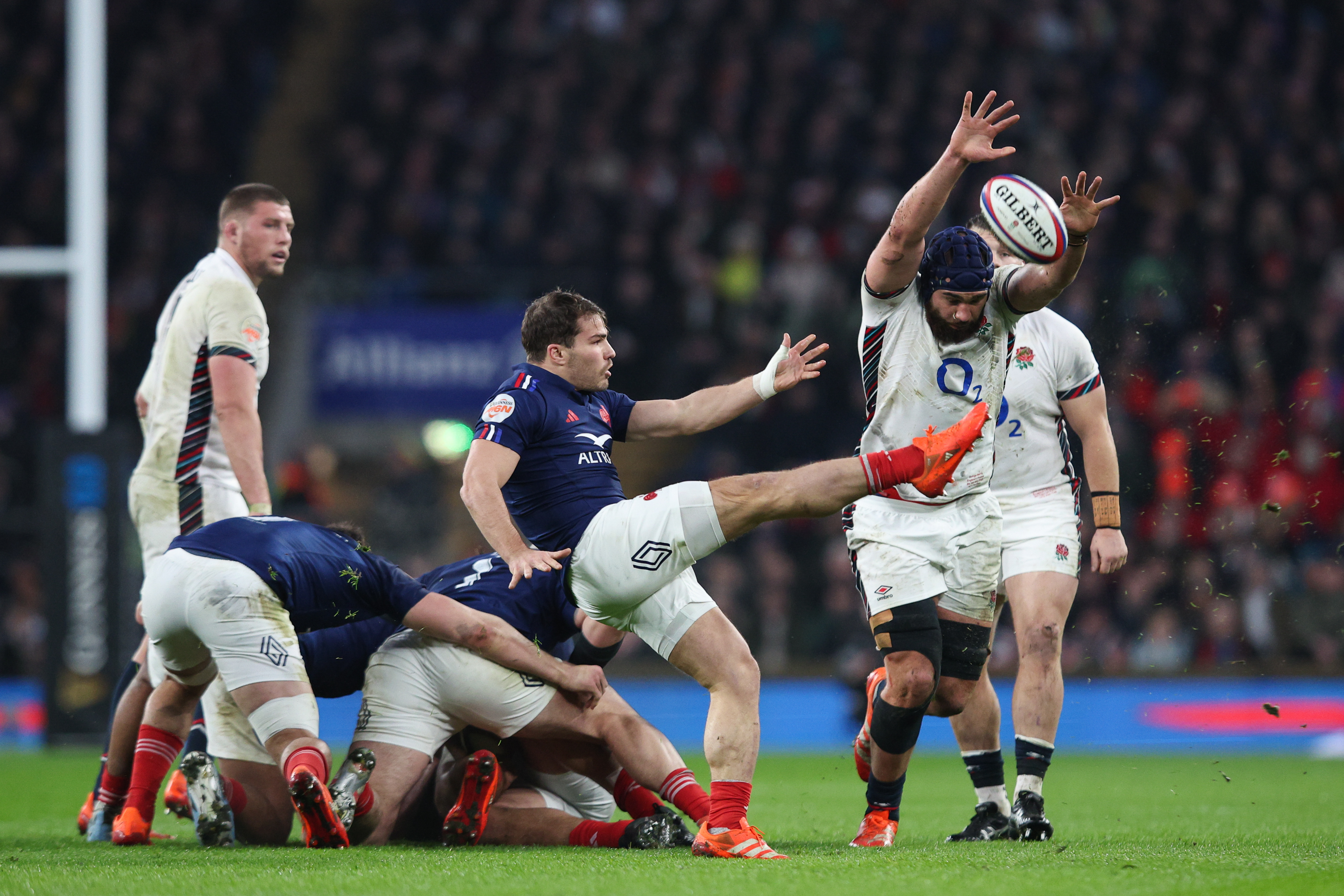 Antoine Dupont of France kicks ahead under pressure from George Martin of England during the Six Nations 2025 rugby match.