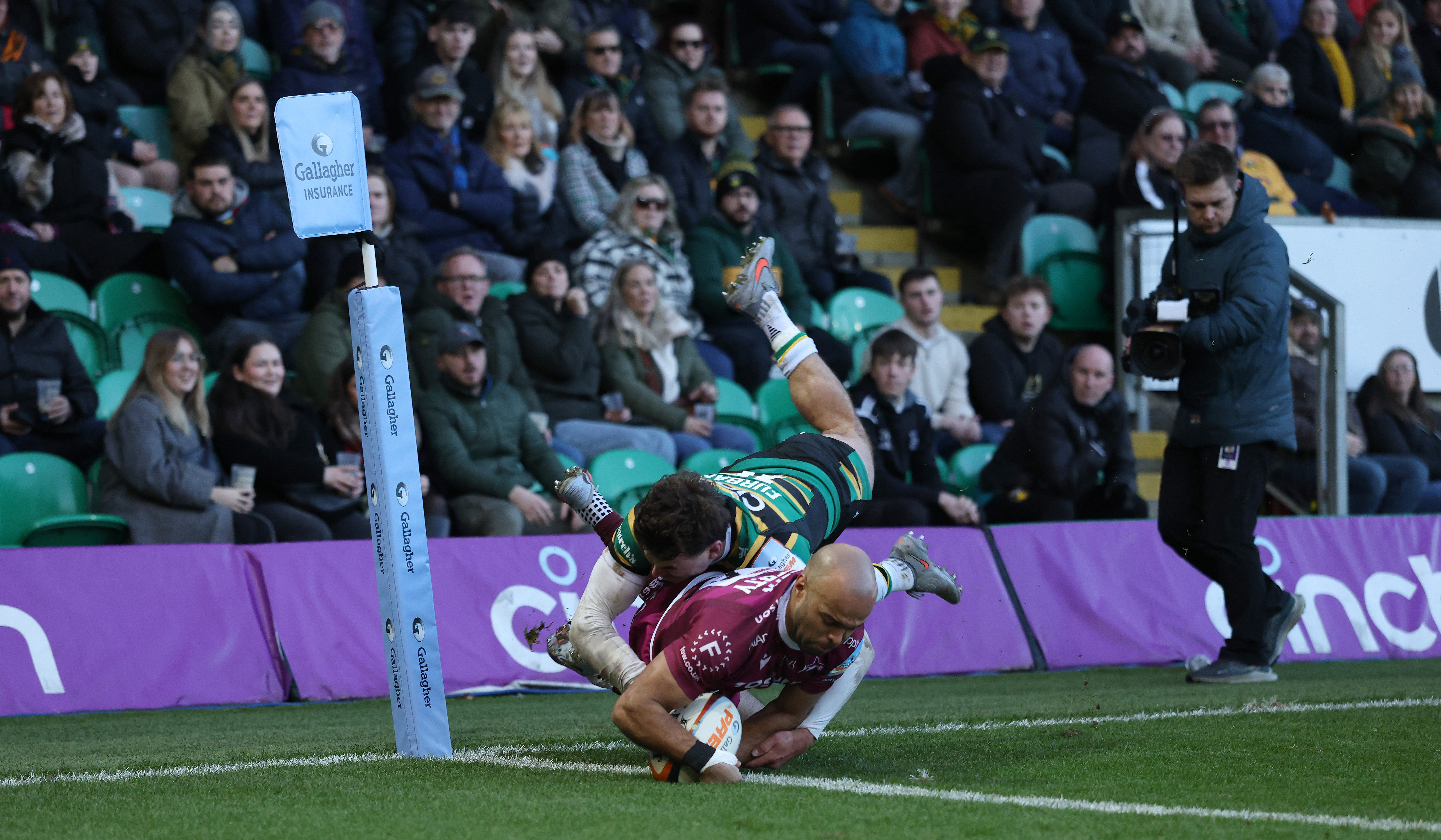 Tom O'Flaherty of Sale Sharks scores a try while George Furbank of Northampton Saints attempts to tackle him.