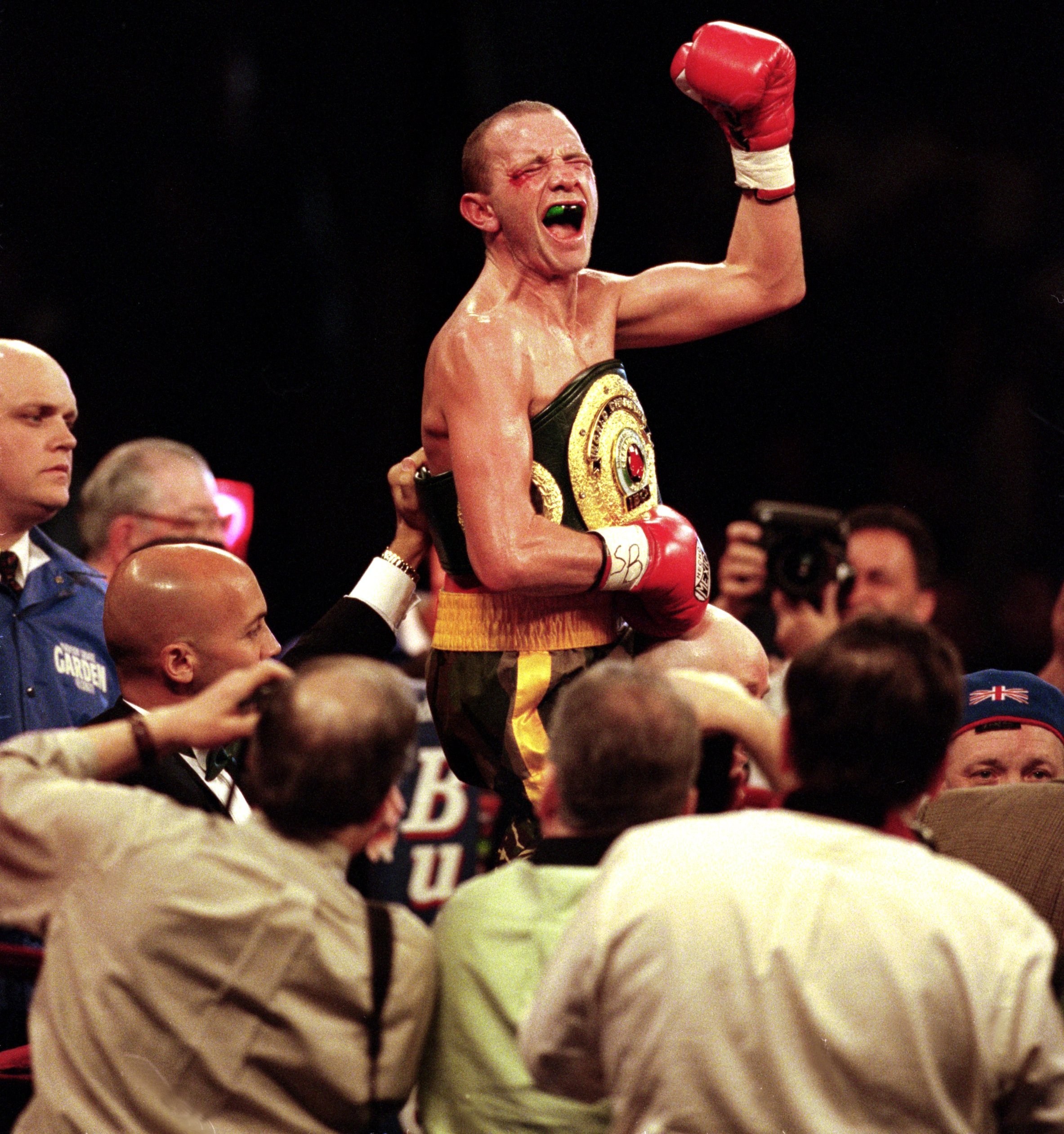 Paul Ingle celebrates with his championship belt and a raised fist after defeating Junior Jones.