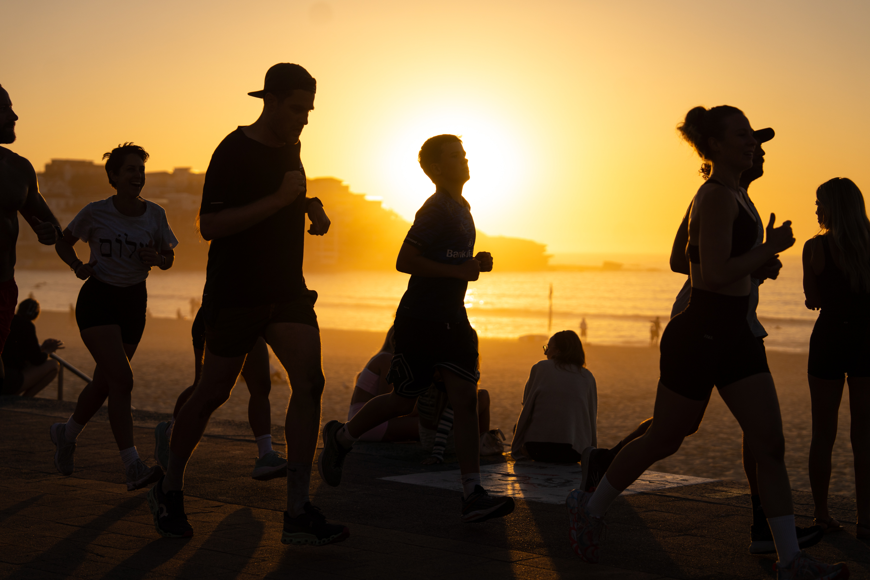 People run past Bondi Beach at sunrise, five days after a mass shooting.