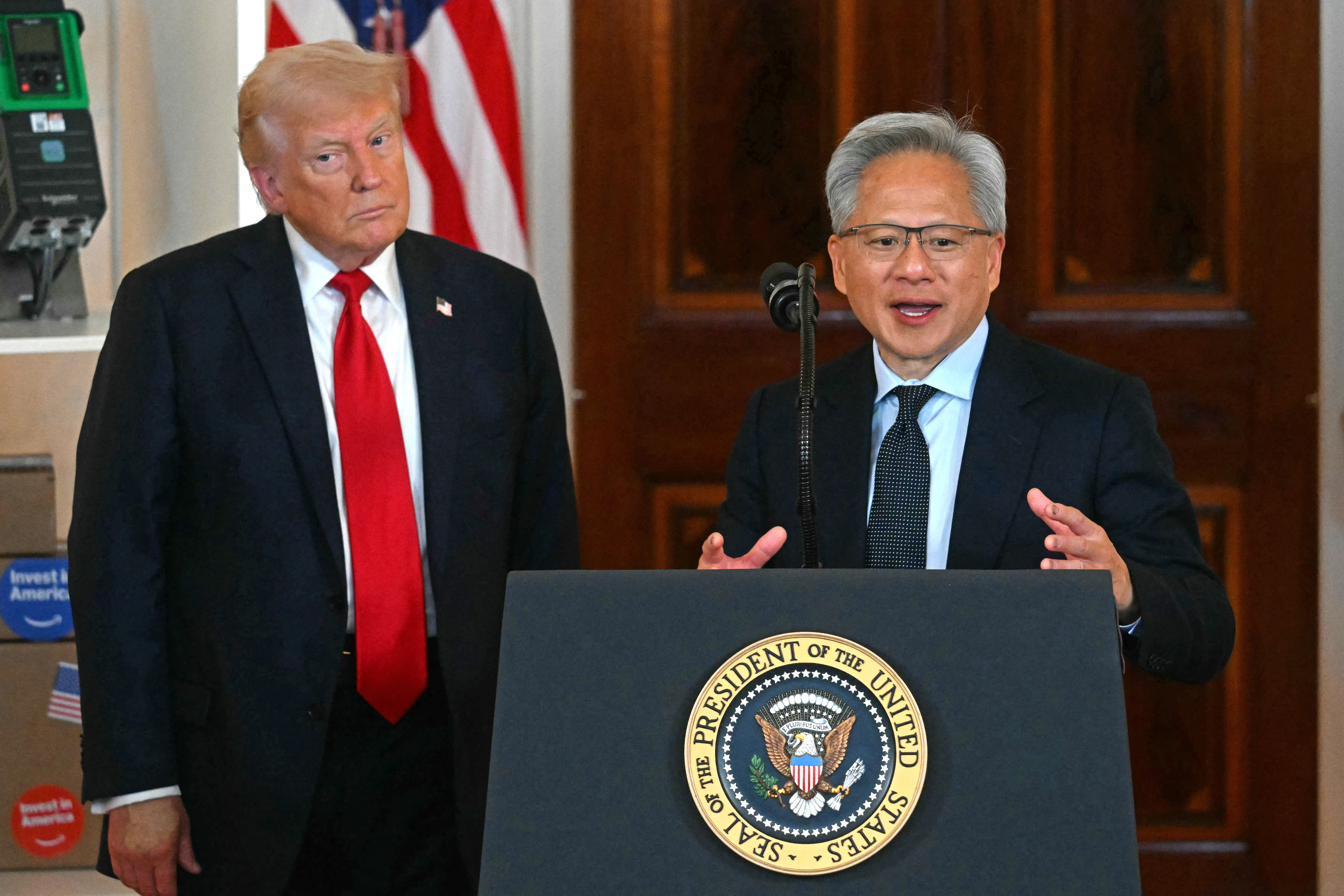 Nvidia CEO Jensen Huang speaks while US President Donald Trump stands next to him.