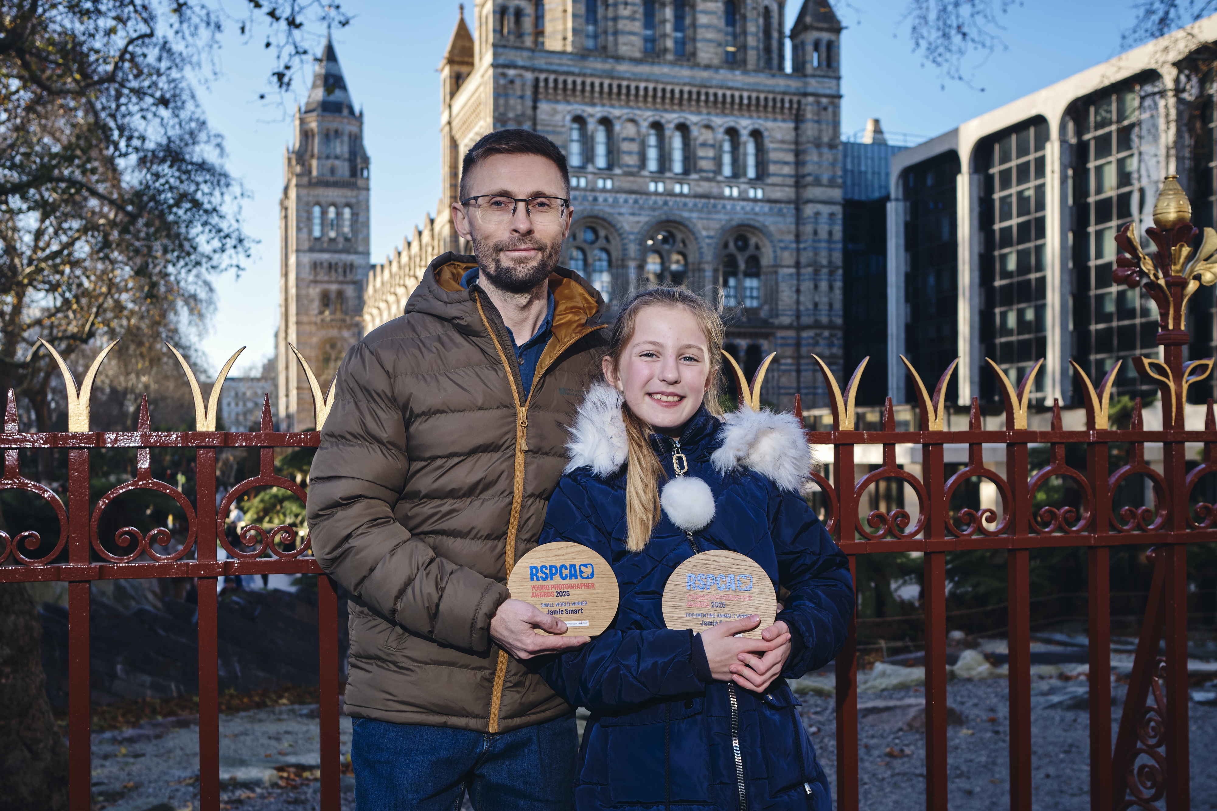 Jamie Smart and her father James holding their two "RSPCA Young Photographer Awards 2025" plaques, Jamie for Small World Winner and Documenting Animals Winner.