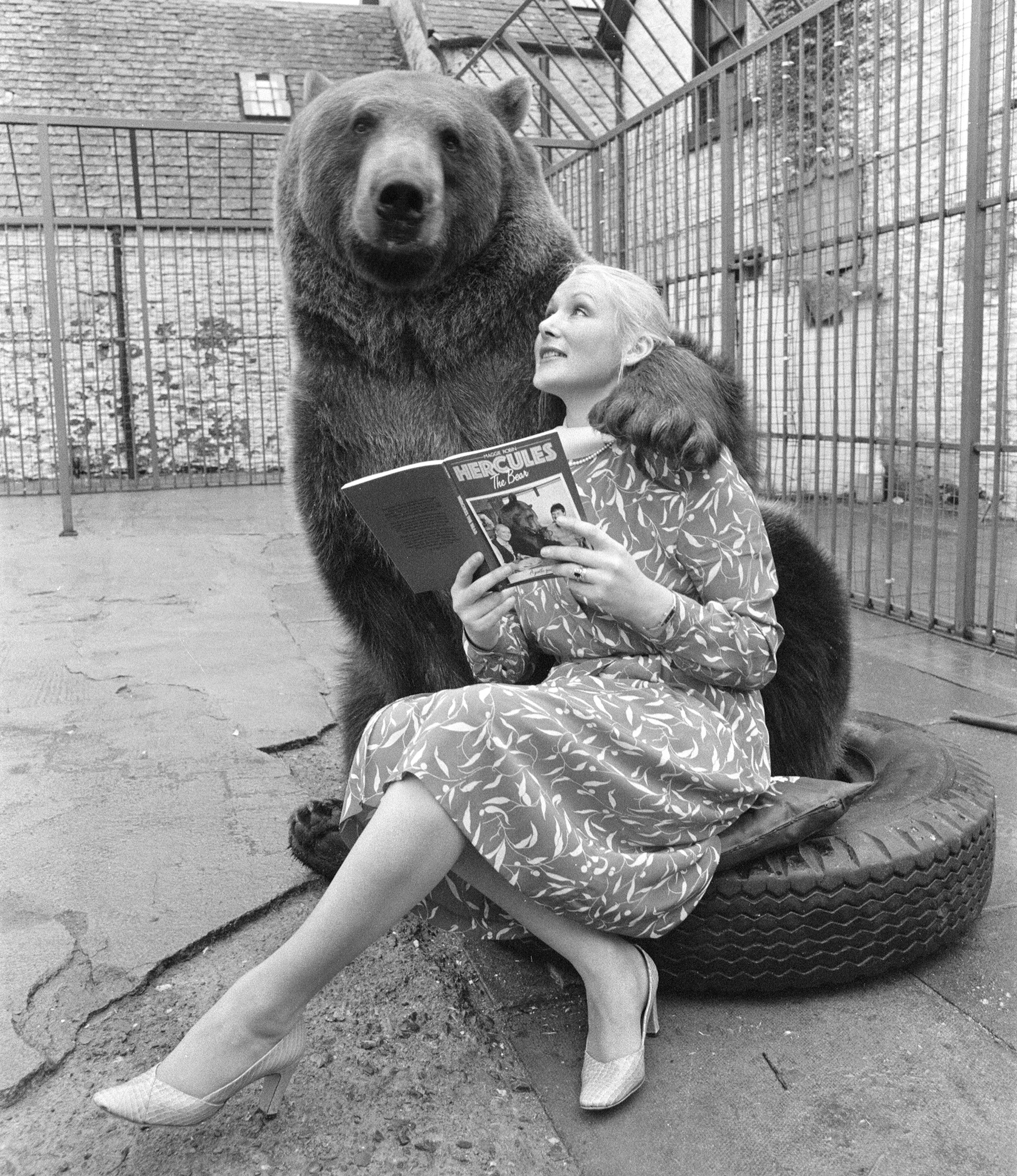 Hercules the Grizzly Bear with owner Maggie Robin, who is holding a book about him.